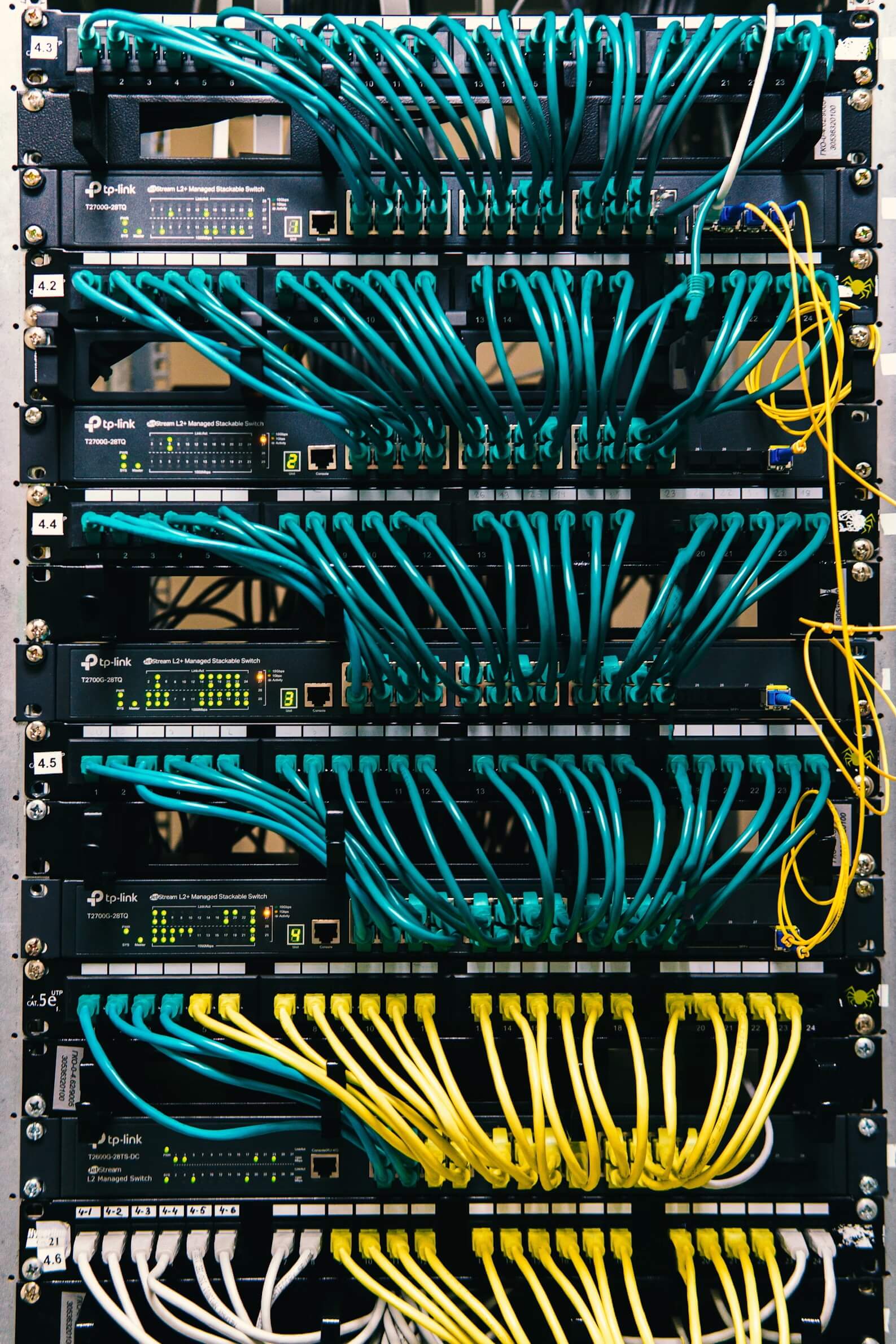 A rack of switching equipment, connected by dozens of ethernet cables